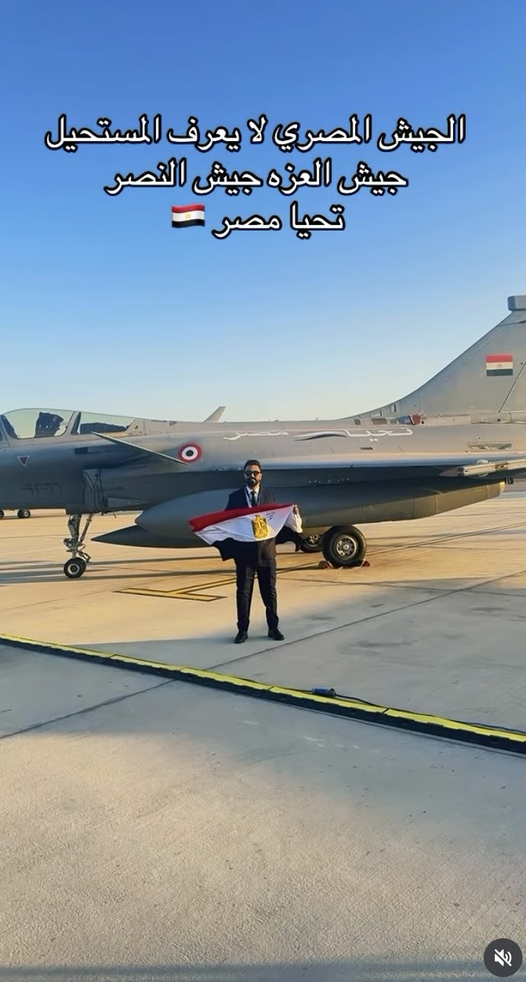 Mansour beside a fighter aircraft holding an Egyptian flag